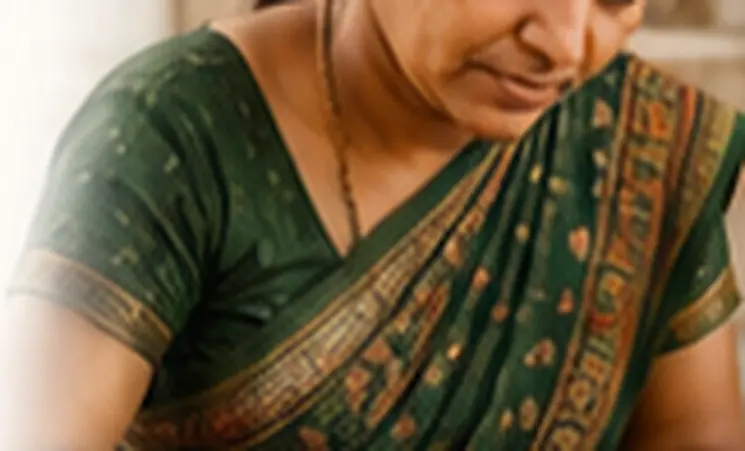 Artisan in a green saree working on traditional Rabari embroidery for the TAARA platform